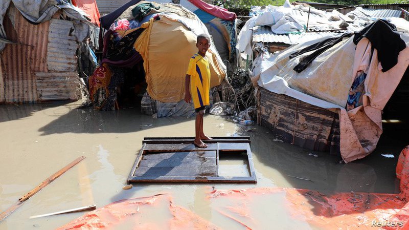 Image 1: A Somali boy stands on a wooden cupboard after heavy rain flooded the neighborhood in Mogadishu, Somalia, October 21, 2019 (Reuters)